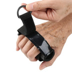 Hand wearing a black adaptive grip aid with adjustable strap for limited mobility support