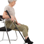 Senior woman using adaptive sock aid tool while seated in a chair