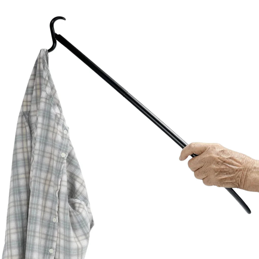 Elderly hand using a black dressing stick to pick up a plaid shirt, adaptive daily living aid