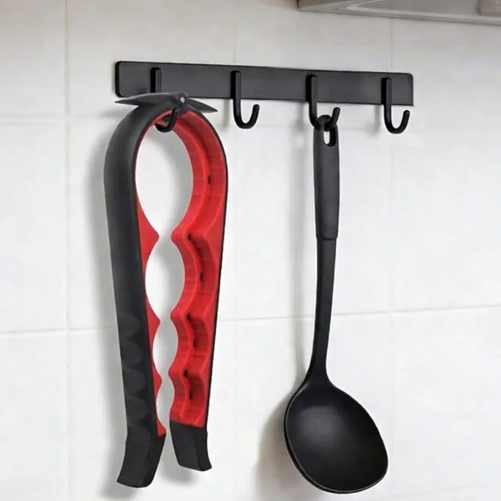 Red and black jar opener and black ladle hanging on kitchen wall hooks