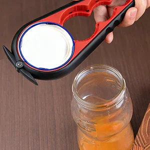 Ergonomic jar opener tool opening a glass jar on a wooden table