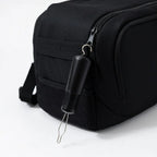 Adaptive button hook zipper pull attached to black bag, arthritis-friendly tool for easy use