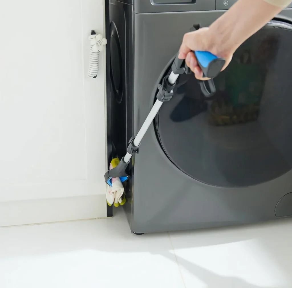 Reaching aid grabber tool picking up laundry behind washing machine