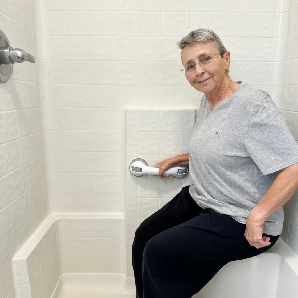 Senior woman using suction grab bar for safety while sitting in bathtub