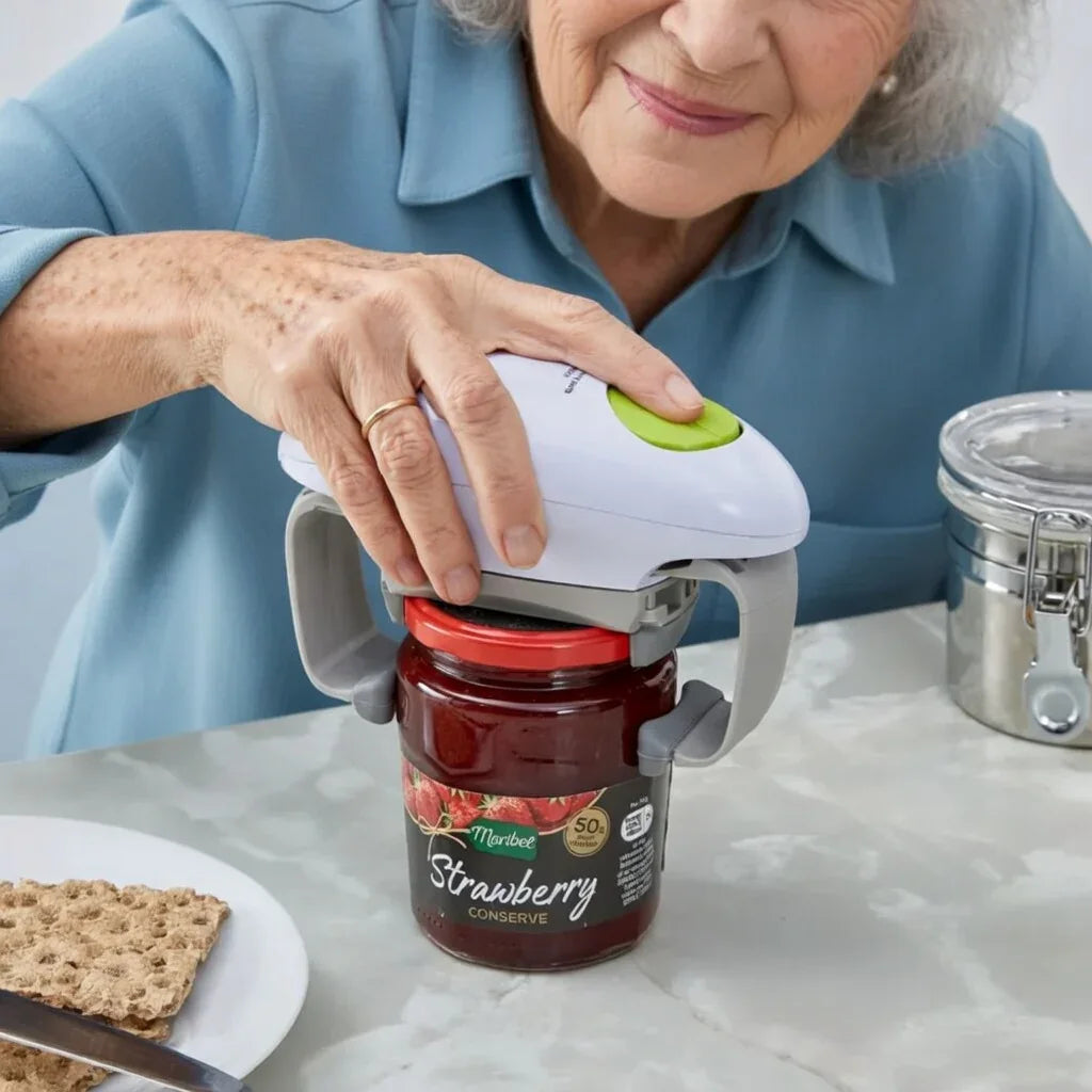 Elderly woman using an automatic jar opener to open a strawberry jam jar on a kitchen table.