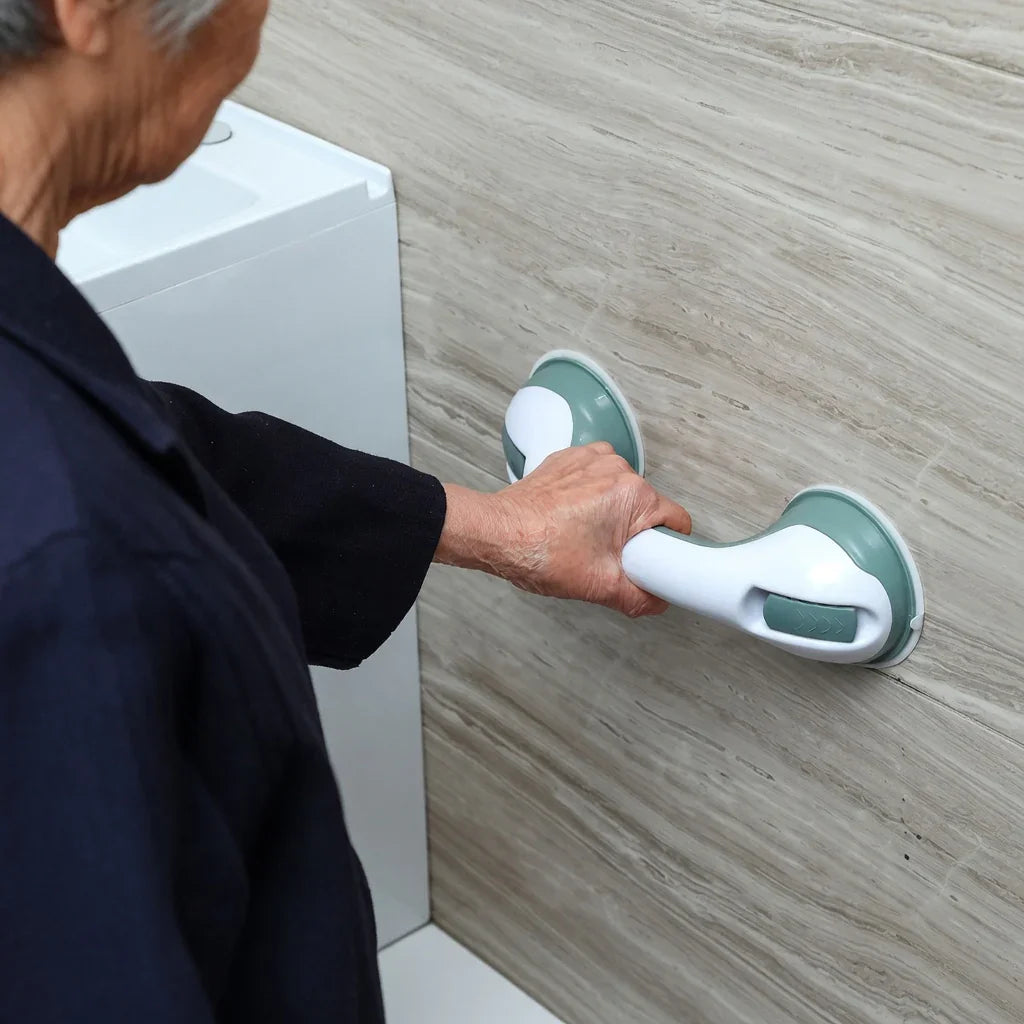 Senior using suction grab bar on bathroom wall for support and safety