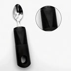 Adaptive spoon with ergonomic black non-slip grip handle, ideal for limited mobility