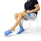 Man using blue sock aid device while seated, adaptive aid for limited mobility